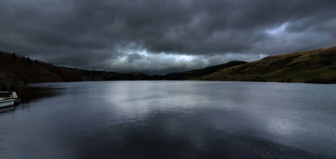 Randonner par temps orageux sur un lac en Auvergne
